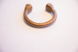 An antique African copper cuff bracelet with a warm patina and etched geometric designs.