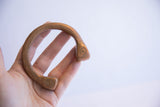 Antique African copper cuff bracelet held open to show its scale and etched design.