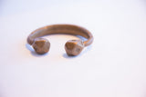 Geometric etchings on the faceted ends of the antique copper alloy cuff.