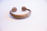 Angled view of the antique African cuff highlighting its aged patina and solid form.