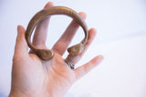Antique African copper cuff bracelet held in hand, demonstrating its substantial scale and form.