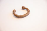 Three-quarter profile of the antique African copper cuff highlighting its sculptural form.