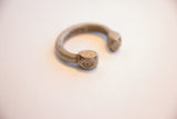 Hand-etched geometric pattern on the faceted end of an antique aluminum cuff.