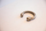 Side view of antique aluminum cuff with faceted geometric ends and aged patina.