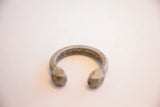 Antique aluminum African cuff bracelet showing its characteristic open C-shape.