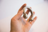 Geometric, hand-stamped base and aged patina of an antique aluminum cuff.