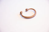 Aged patina on the C-shaped profile of the antique copper snake cuff.