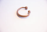 The open C-shape of the antique African copper snake cuff bracelet.