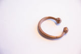 Angled view of the antique African copper bracelet's open C-shape.