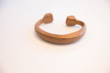The C-shaped opening and warm patina of the antique copper snake cuff.