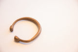 The handcrafted form and open shape of an antique African bracelet.
