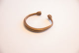 The open shape and smooth, aged surface of the antique snake cuff bracelet.