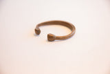 Smooth, stylized snake-head terminals of the antique African cuff bracelet.