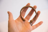 Antique African snake cuff bracelet held in a hand to show scale.