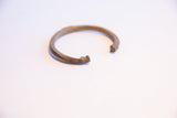 Detail of the vintage African cuff bracelet's open ends, one showing hand-etched lines.