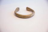 Side profile view of the antique bronze cuff bracelet showing the opening.
