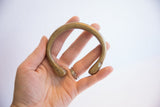 The substantial form and scale of a collectible African bronze snake cuff in hand.