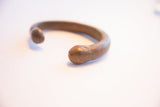 Smooth, sculpted snake head terminal on the antique African bracelet.