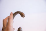 Detailed view of the hand-carved snake head terminal with an aged patina.