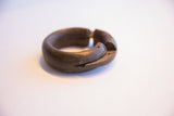 The handmade interlocking point and aged patina of the antique African bracelet.