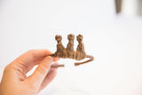 A profile view of the three hand-sculpted figurines on the vintage Dogon cuff.