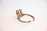 The open C-shape and aged patina of a vintage African Baole Dogon cuff bracelet.