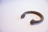 Aged dark metal texture at the opening of the antique African Manilla bracelet.