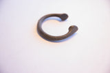 Detailed close-up of the antique African manilla bracelet, showing its textured metal and sculpted end.