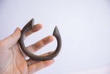 Rustic patina and distinctive pointed tips of an antique African manilla bracelet.