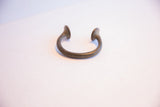 The open C-shape and flared terminals of an antique African cuff bracelet.