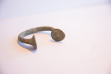 Profile view of the antique manilla cuff showing its textured patina and flared ends.