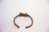 Overhead view of the vintage African cricket cuff bracelet showing its open form.