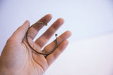 Vintage African cuff bracelet held in hand to demonstrate its scale and form.