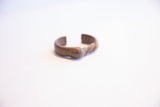 Hand-forged African currency bracelet showing its abstract cuff shape.