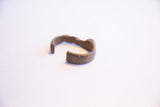 Angled view showing the opening of the vintage African cuff bracelet and its dark patina.