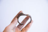 Vintage African cuff bracelet held to show its small scale and abstract shape.