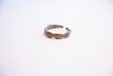 The open cuff and hand-formed wavy edge of a vintage African bracelet.