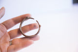 Vintage African child's bracelet held in hand to illustrate its small size and scale.