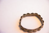 Hinge detail and aged metal surface of a vintage African floral bracelet.