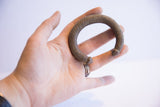 Vintage African striped cuff bracelet held in a palm to show its form and scale.