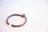 The handcrafted knot and aged, textured surface of a vintage African bracelet.
