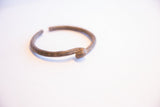 Side profile of a handmade African cuff showing its aged texture and knotted end.