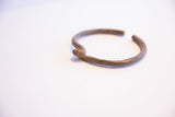 The unique looped knot and hand-forged texture of the vintage African bracelet.