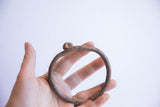 Hand holding the vintage African cuff, showing its handcrafted, knotted form.