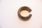 An angled view of the antique African cuff showing its aged patina and geometric engravings.