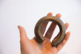 Antique African cuff bracelet held in hand, showing its substantial form and scale.
