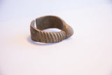 Side profile of the vintage African cuff bracelet showing its opening and ribbed texture.