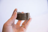 Vintage African cuff bracelet with etched designs held in hand to show scale.