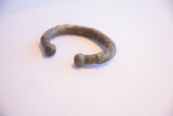 Profile view of an antique African silver cuff bracelet with a heavy, oxidized patina.