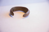 Pitted, time-worn texture on the rounded tip of the antique African cuff.